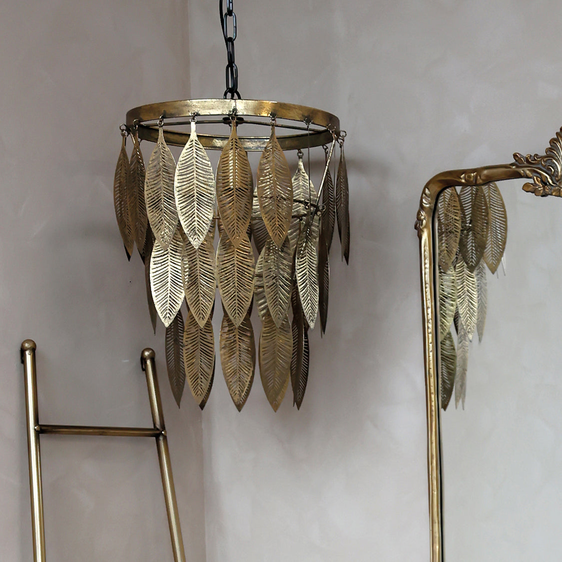 Denne fine loftlampe i messing har et flot lysekrone inspireret udtryk med de flotte blade der hænger ned og omkranser pæren.